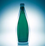 En dubbel exponerad grön Perrier flaska mot vit bakgrund