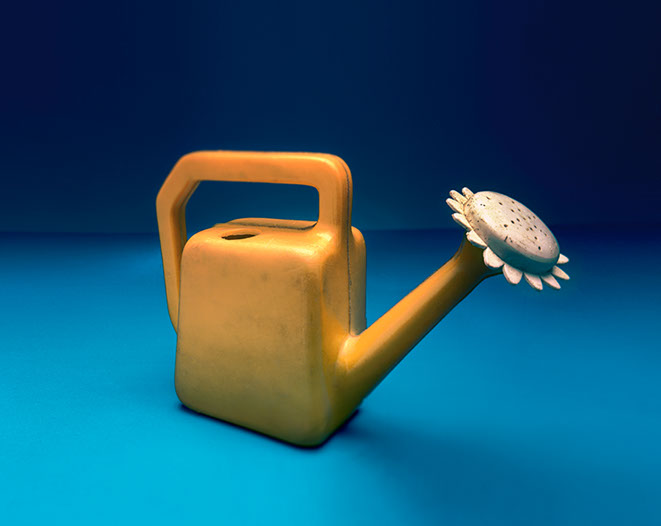 Produktfotografi av en gul leksaks vattenkanna på blå botten